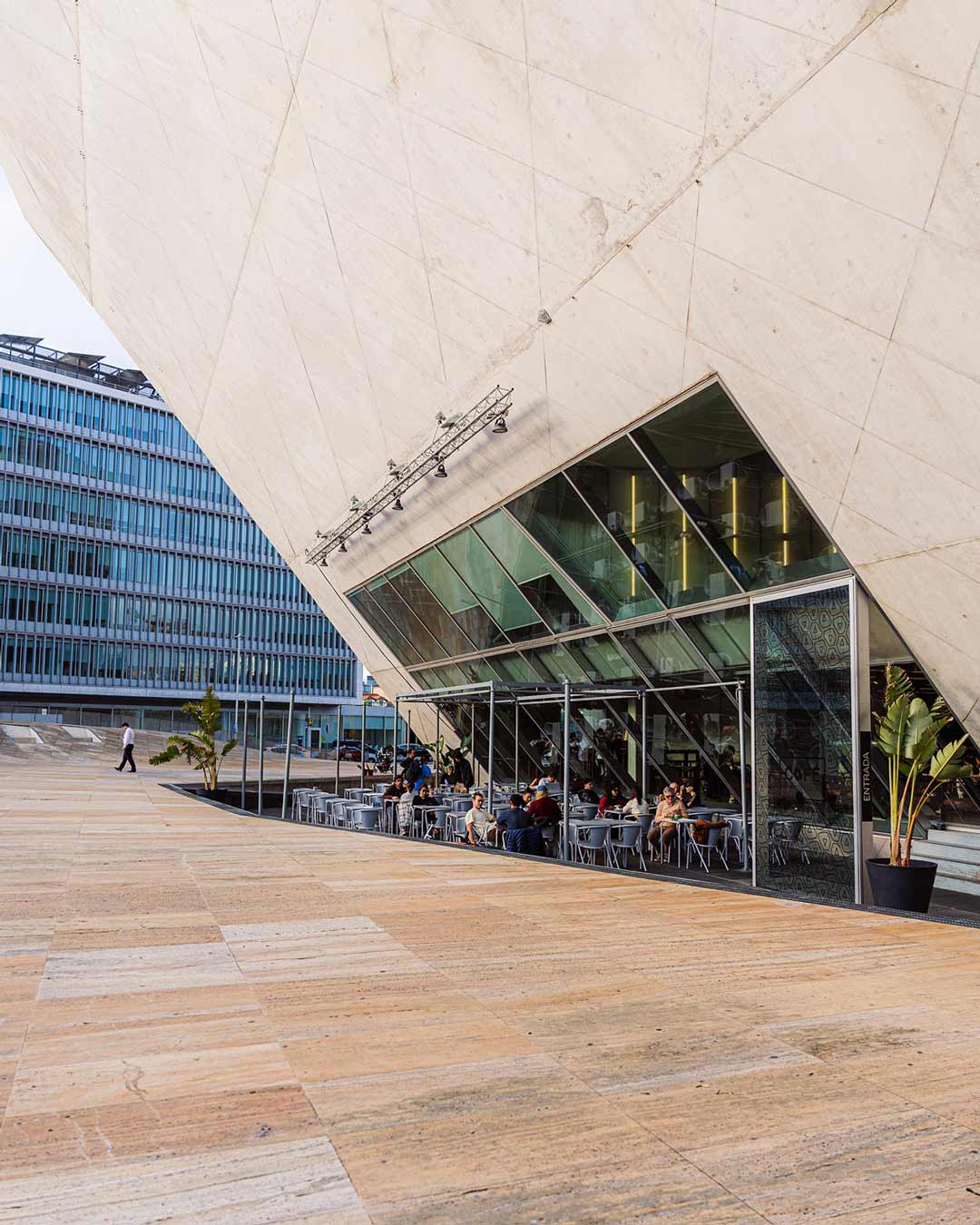 Vista exterior do café da Casa da Música, com destaque para a arquitetura icónica do edifício e o contraste entre as formas geométricas e o ambiente urbano.