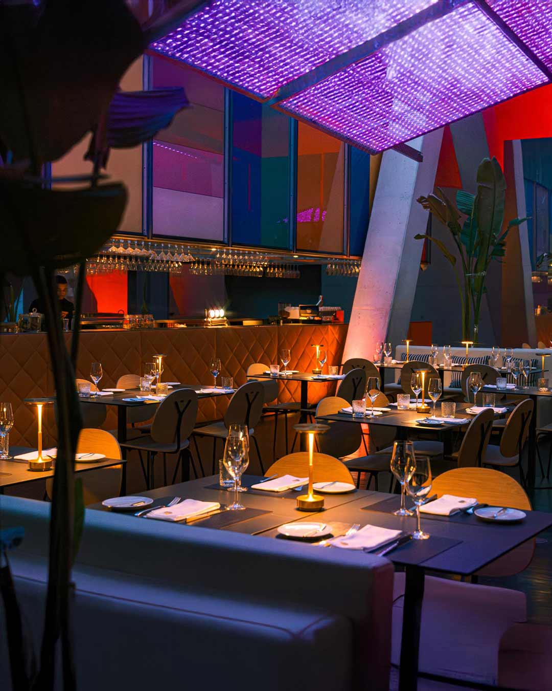 Interior do restaurante da Casa da Música à noite, com luz ambiente suave, mesas preparadas e atmosfera elegante e acolhedora.