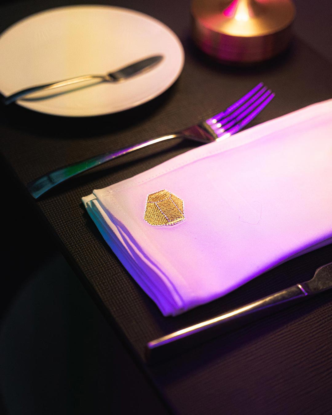 Detalhe do guardanapo do restaurante da Casa da Música, com o logótipo e a forma icónica do edifício bordados com elegância.